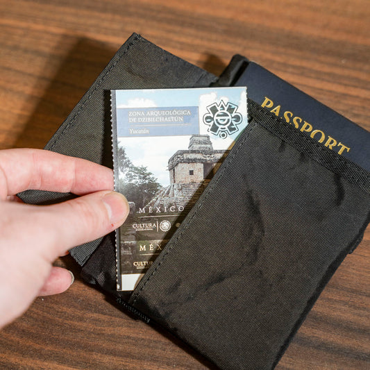 Black travel wallet with a passport and card holder on a wooden surface